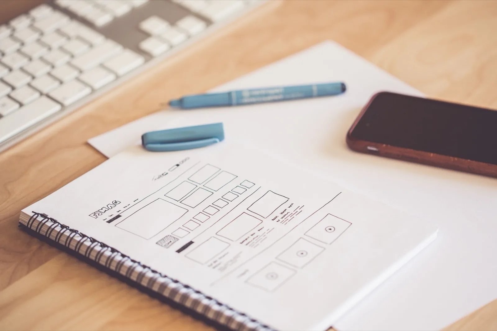 Handgetekende wireframes van een website-lay-out op een schetsblok