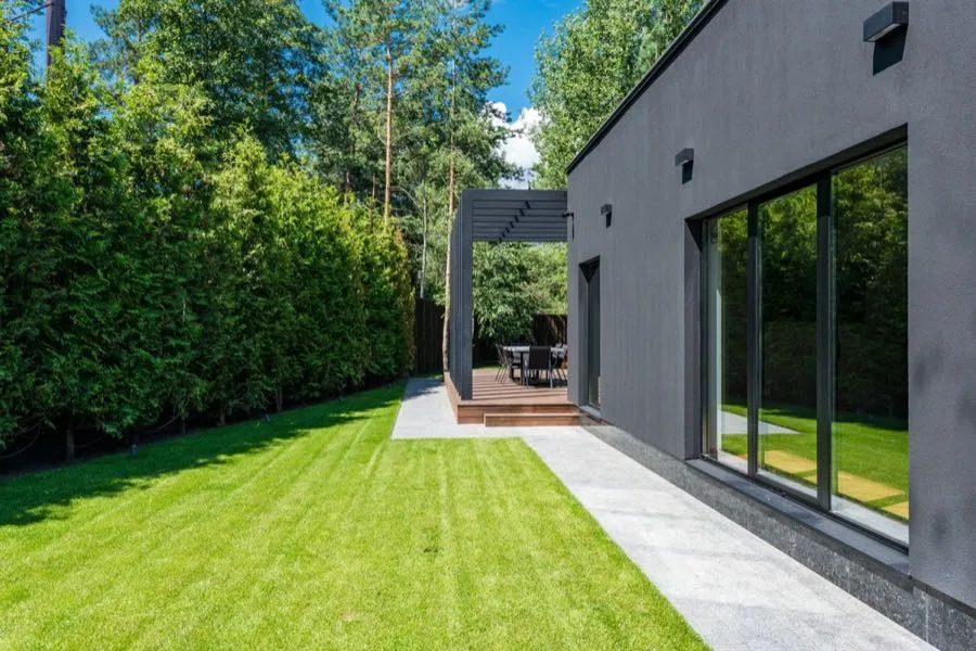 Moderne achtertuin met strakke border en zitgedeelte, aangelegd in Vught