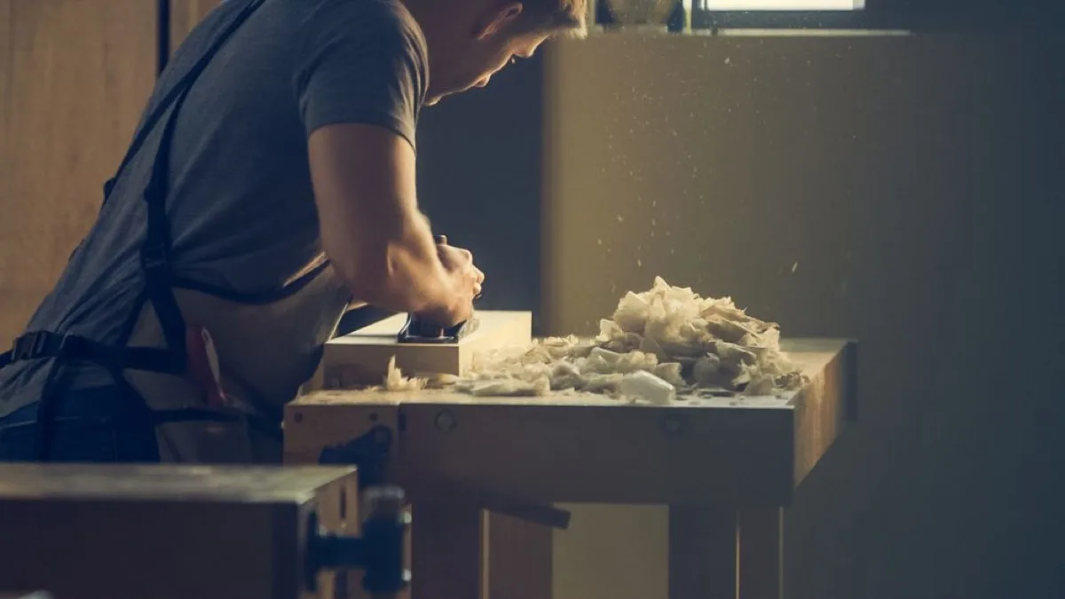 Meubelmaker schaaft hout in de werkplaats van Eik en Linnen
