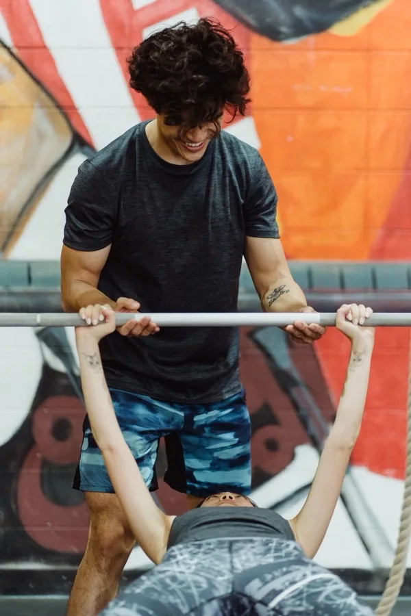 Kevin, coach bij Studio Kracht, begeleidt bankdrukken