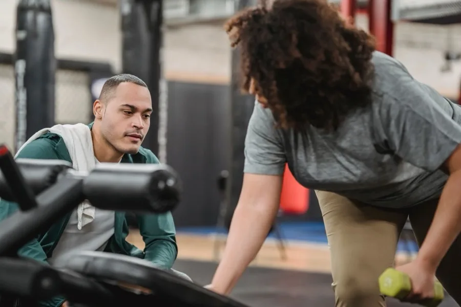 Lotte, coach bij Studio Kracht, begeleidt training met dumbbells